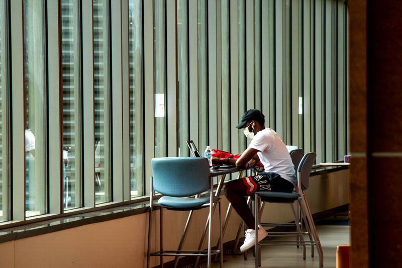 Student on campus studying wearing a mask