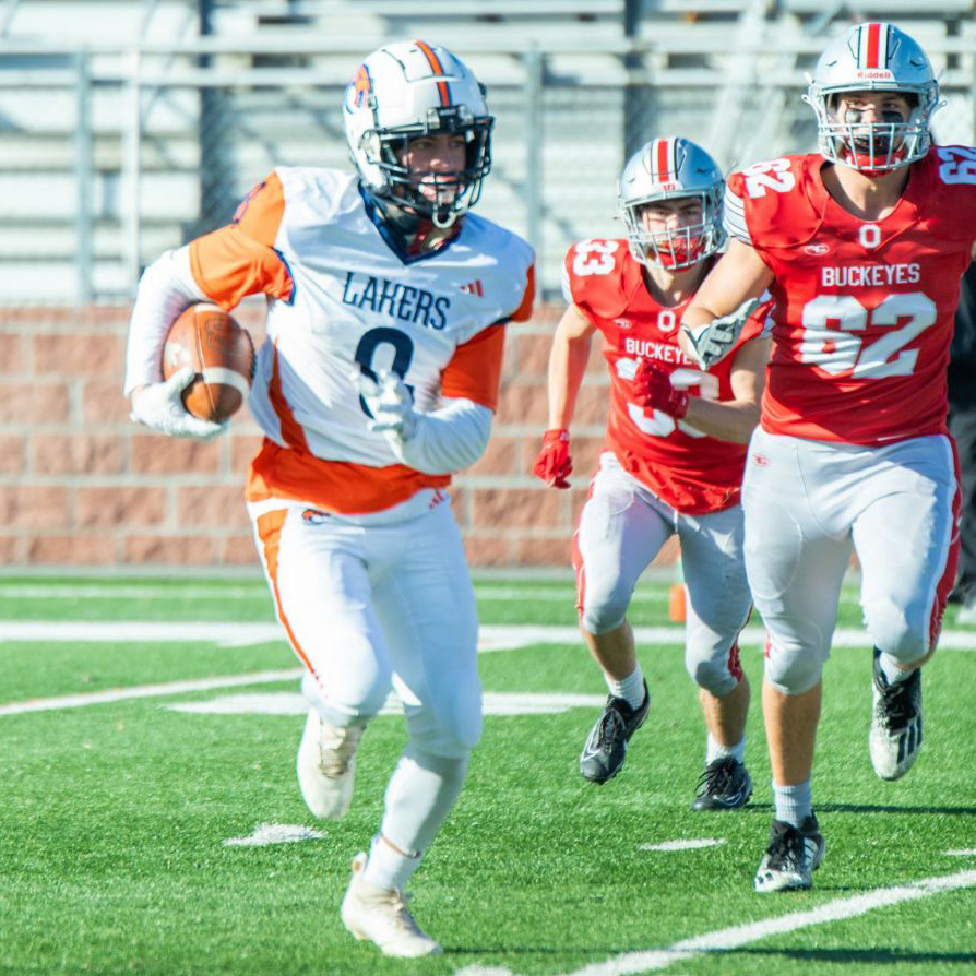 Image of Lakers player #9 Kincaid running away from Buckeyes players. 