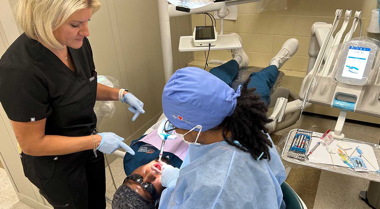 professor showing student how to numb patient